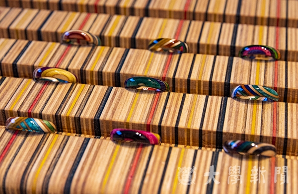폐스케이트보드의 단면을 잘라 사선으로 이어붙여 만든 반지와 반지 받침대의 모습이다.