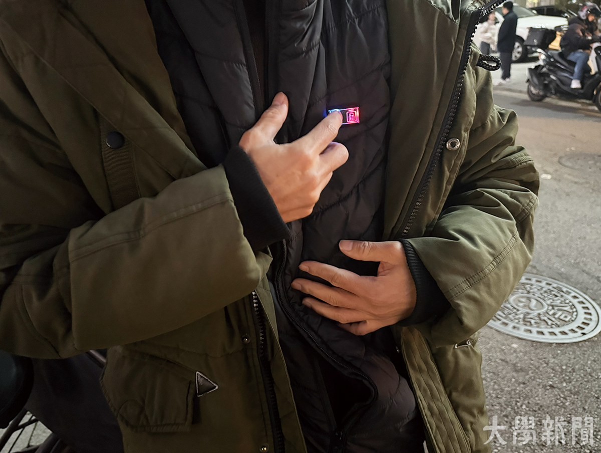 ▲ 배달종사자 D씨가 열선 조끼 전원을 켜는 모습을 보여주고 있다.